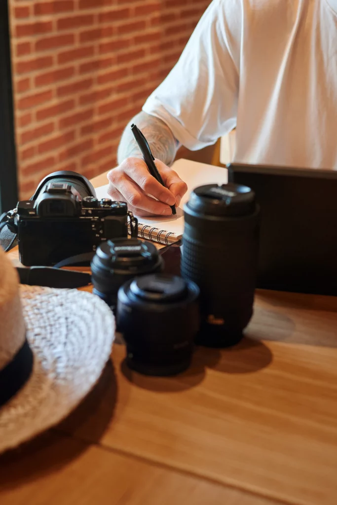closeup-shot-man-pointing-ideas-with-lenses-camera-table