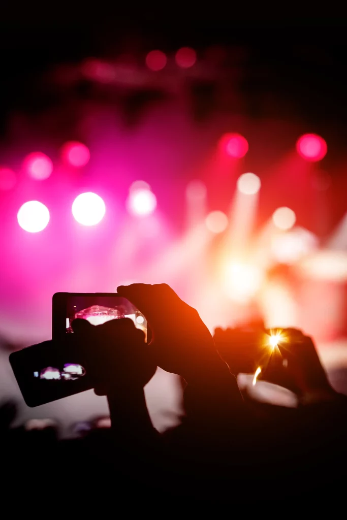 silhouette-hands-using-smartphones-take-pictures-videos-live-music-show